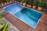 Rectangular pool with slatted cover on wooden deck