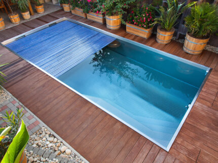 Rectangular pool with slatted cover on wooden deck