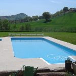 Rectangular outdoor swimming pool with tiled patio