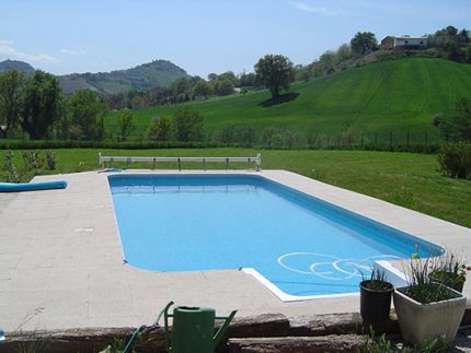 Rectangular outdoor swimming pool with tiled patio