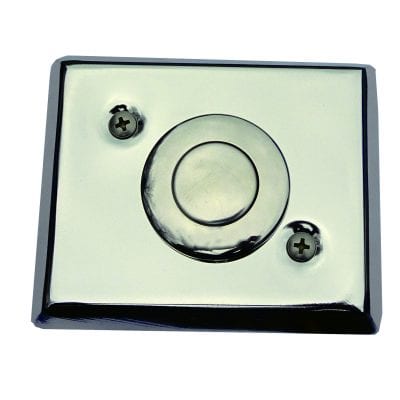 Pneumatic Button x 1 Concrete Chrome rectangular wall plate with a central circular push button, secured by two Phillips screws, reflecting light and showing smudges, isolated against a plain white background.